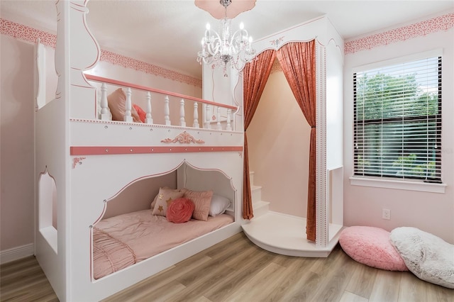 bedroom with wood finished floors and a chandelier