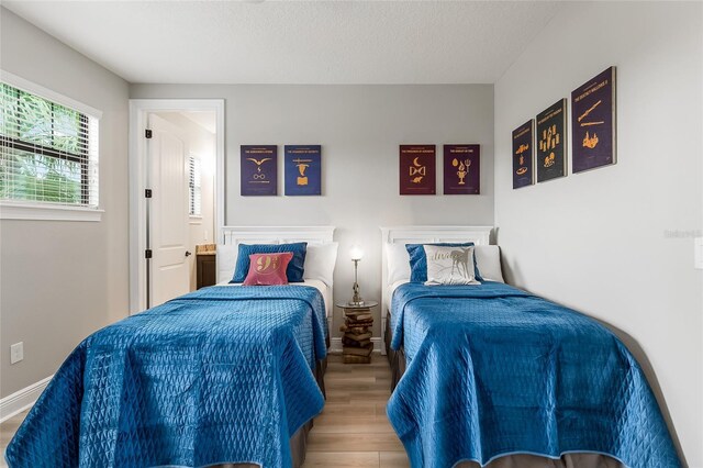 bedroom with wood finished floors and baseboards