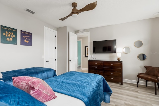bedroom with light wood-style flooring, baseboards, and a ceiling fan