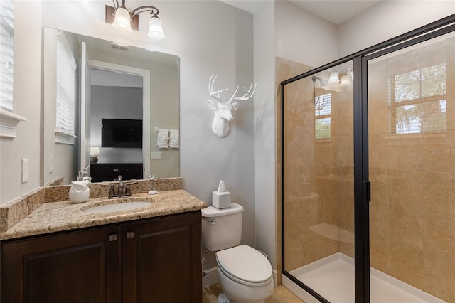 bathroom with a shower stall, toilet, and vanity