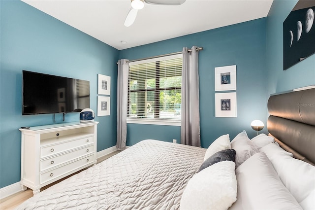 bedroom with baseboards, wood finished floors, and a ceiling fan