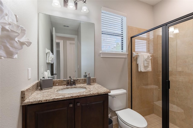 full bathroom featuring a stall shower, vanity, and toilet