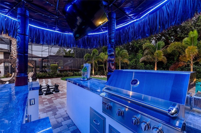 view of patio / terrace featuring area for grilling, fence, and exterior kitchen