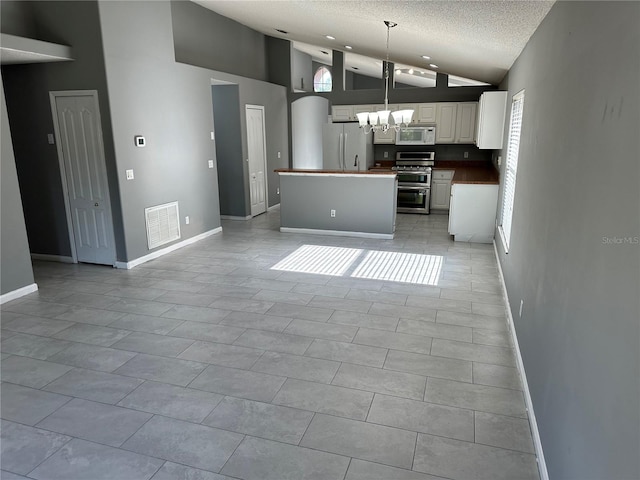 6625 Cherry Grove Cir, Orlando, FL 32809 - kitchen featuring white appliances, a chandelier, a textured ceiling, white cabinetry, and open floor plan