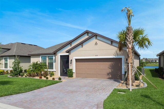 636 San Augusto Dr, Kissimmee, FL 34759 - ranch-style house with stucco siding, a garage, decorative driveway, and a front yard