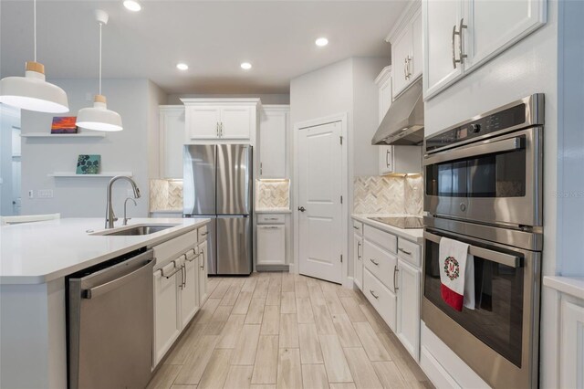 636 San Augusto Dr, Kissimmee, FL 34759 - kitchen featuring appliances with stainless steel finishes, a sink, under cabinet range hood, light countertops, and recessed lighting