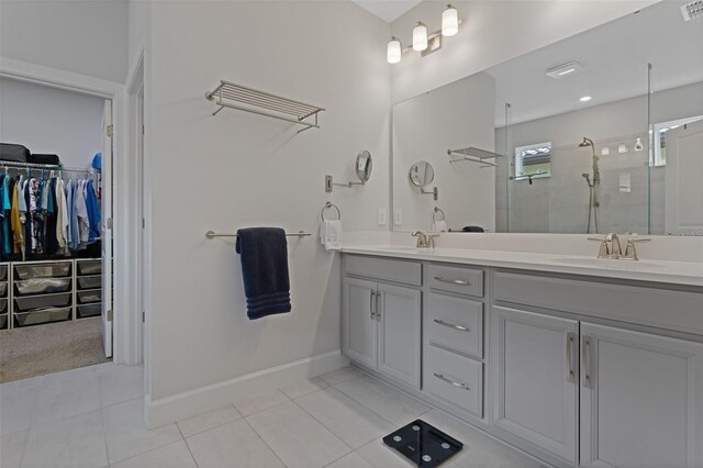 636 San Augusto Dr, Kissimmee, FL 34759 - bathroom featuring tile patterned floors, double vanity, a stall shower, a spacious closet, and baseboards