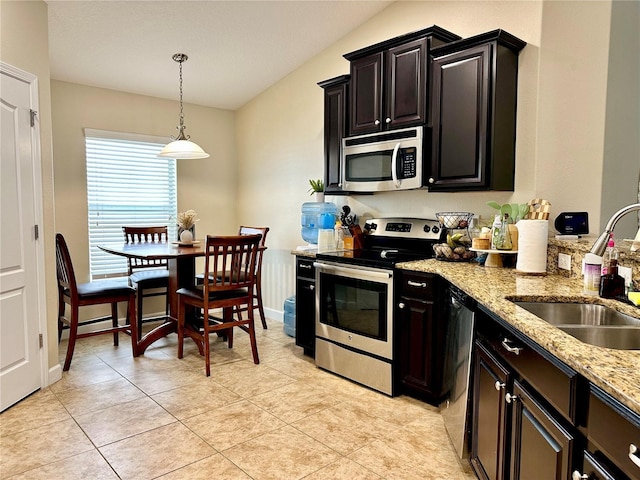 1474 Lakeside Ave, Davenport, FL 33837 - kitchen with appliances with stainless steel finishes, a sink, light stone counters, hanging light fixtures, and dark cabinets