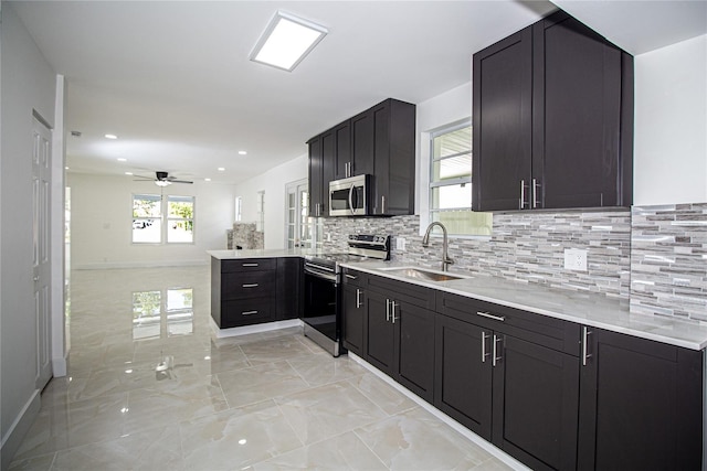 4324 Garden Ave, West Palm Beach, FL 33405 - kitchen featuring appliances with stainless steel finishes, a sink, a peninsula, a ceiling fan, and light marble finish flooring