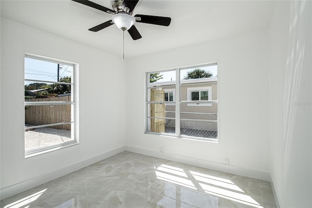 4324 Garden Ave, West Palm Beach, FL 33405 - unfurnished room featuring healthy amount of natural light, baseboards, a ceiling fan, and light marble finish floors