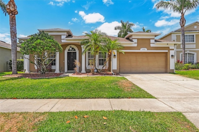 mediterranean / spanish-style house featuring stucco siding, a garage, a front yard, and driveway