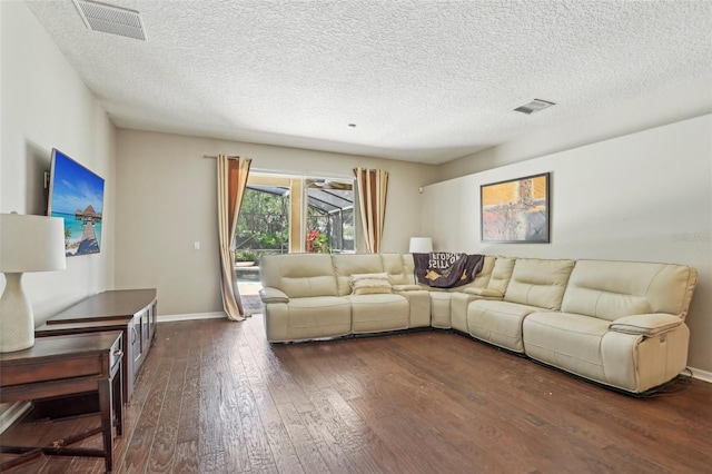 living area featuring dark wood-style floors, baseboards, and a textured ceiling