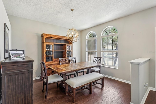 dining area with dark wood-style floors, a chandelier, baseboards, and a textured ceiling