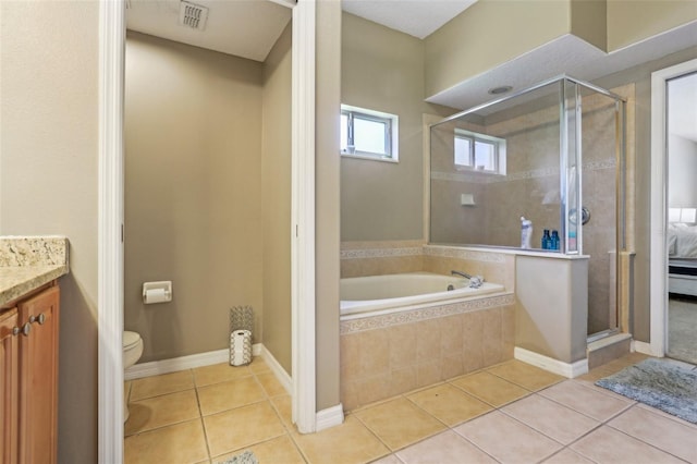 bathroom with a shower stall, toilet, and tile patterned floors