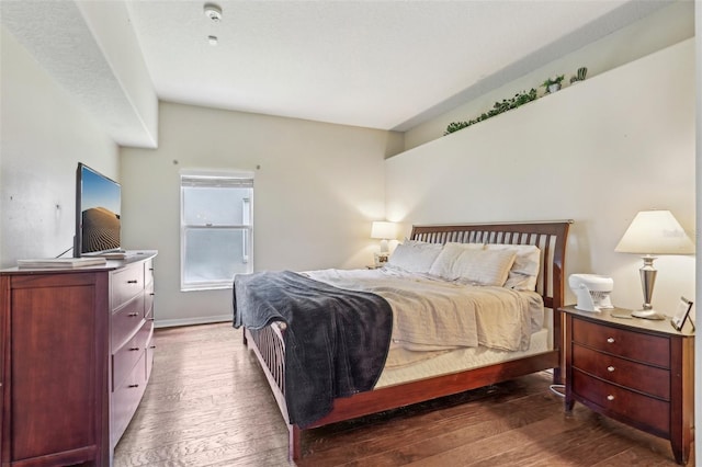 bedroom with hardwood / wood-style flooring and baseboards