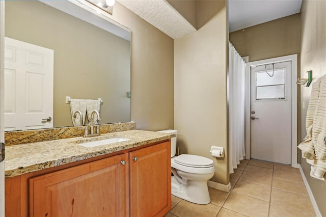 full bath featuring tile patterned floors, toilet, vanity, and baseboards