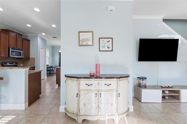 1978 Fishtail Fern Way, Ocoee, FL 34761 - kitchen with stainless steel microwave, crown molding, recessed lighting, light tile patterned floors, and backsplash
