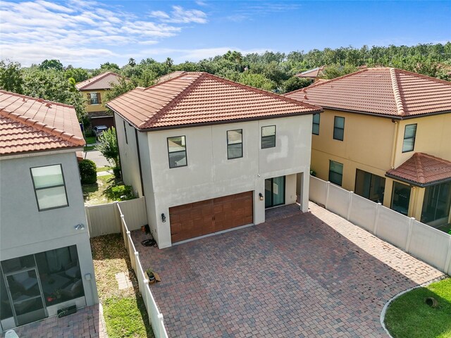 1978 Fishtail Fern Way, Ocoee, FL 34761 - view of front of house with a garage, stucco siding, a tiled roof, decorative driveway, and fence