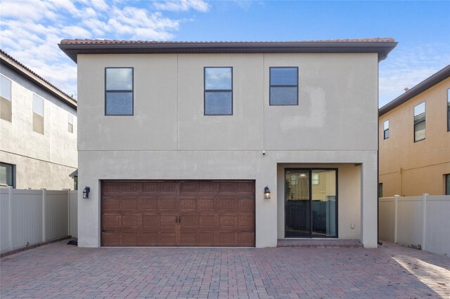1978 Fishtail Fern Way, Ocoee, FL 34761 - back of house featuring fence, stucco siding, an attached garage, and decorative driveway