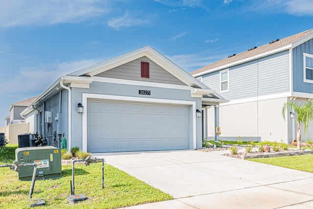 ranch-style home featuring central air condition unit, stucco siding, and concrete driveway