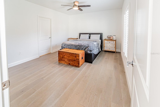 bedroom featuring light wood-style floors, a ceiling fan, and baseboards