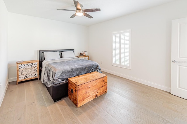 bedroom featuring light wood-style flooring, baseboards, and ceiling fan