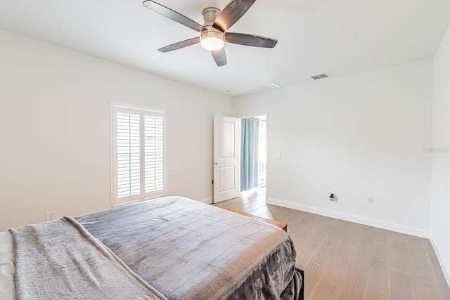 bedroom featuring light wood-style floors, baseboards, and a ceiling fan