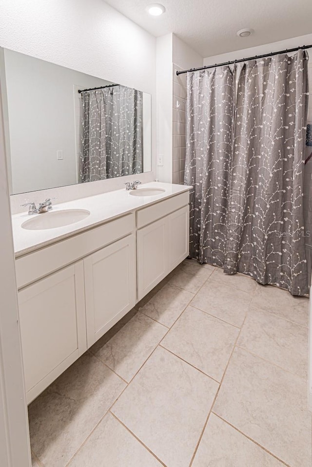 bathroom with double vanity, tile patterned floors, and a shower with curtain