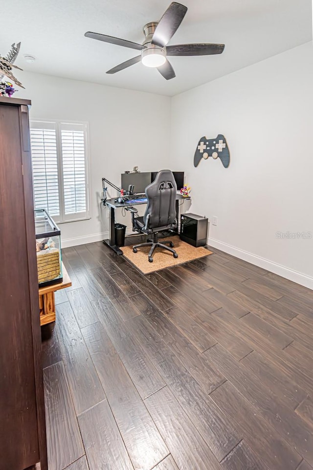 home office featuring dark wood-style floors, a ceiling fan, and baseboards