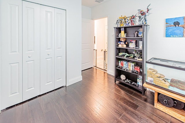 bedroom featuring dark wood finished floors, a closet, and baseboards