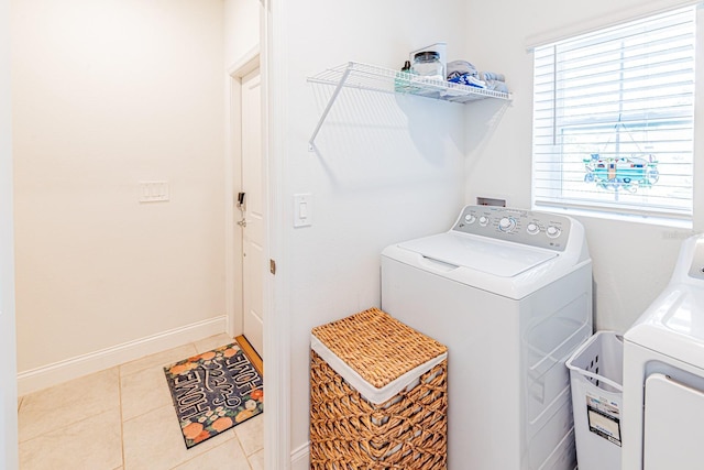 laundry room featuring washing machine and dryer, tile patterned flooring, and baseboards