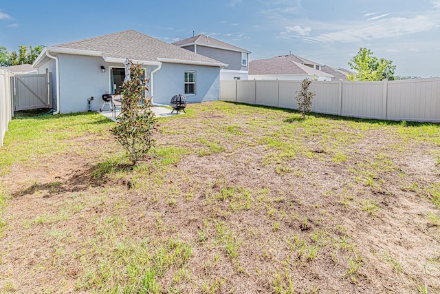 back of house with stucco siding, a patio area, and roof with shingles