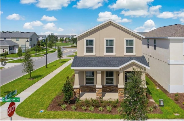 11807 Charades St, Orlando, FL 32832 - view of front facade with stucco siding, stone siding, covered porch, a front lawn, and a residential view
