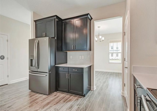 11807 Charades St, Orlando, FL 32832 - kitchen featuring stainless steel fridge, light wood finished floors, light countertops, and a chandelier