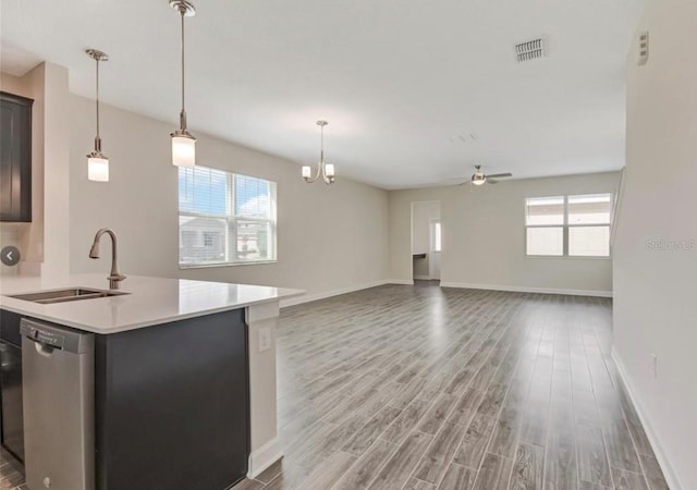 11807 Charades St, Orlando, FL 32832 - kitchen with stainless steel dishwasher, a sink, plenty of natural light, and light countertops