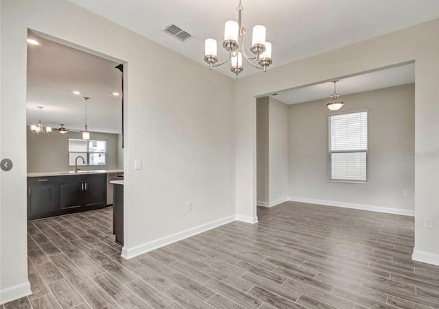 11807 Charades St, Orlando, FL 32832 - unfurnished room with a chandelier, wood finished floors, baseboards, and a sink
