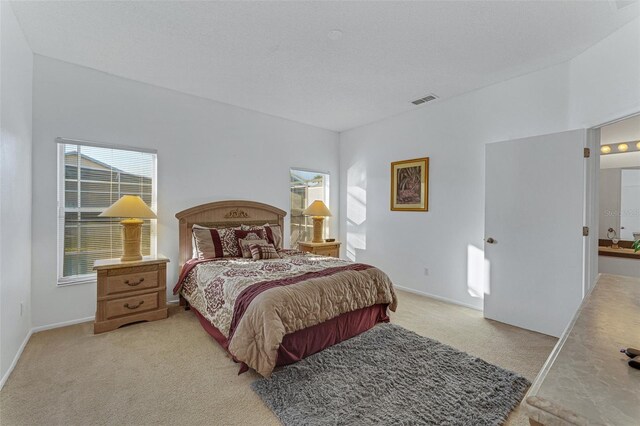 bedroom featuring light carpet and baseboards