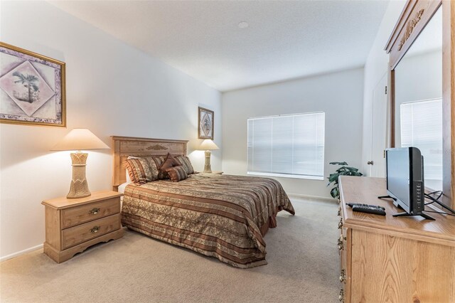 bedroom with light carpet and baseboards