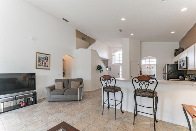 living area featuring arched walkways, recessed lighting, and baseboards