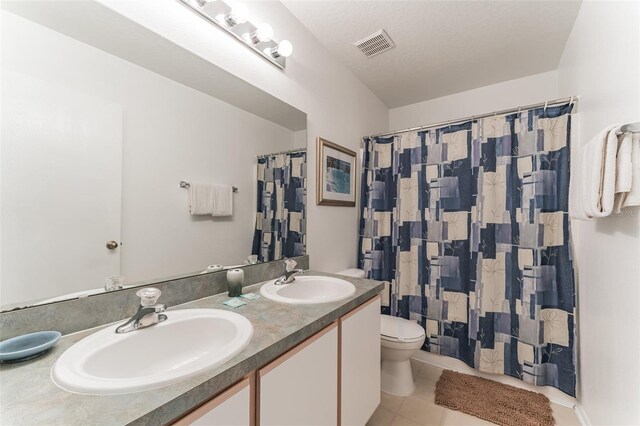 bathroom featuring tile patterned floors, toilet, double vanity, and curtained shower