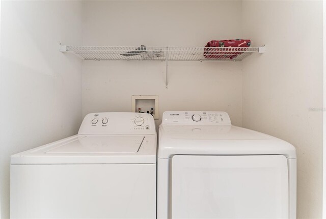 clothes washing area with washer and clothes dryer