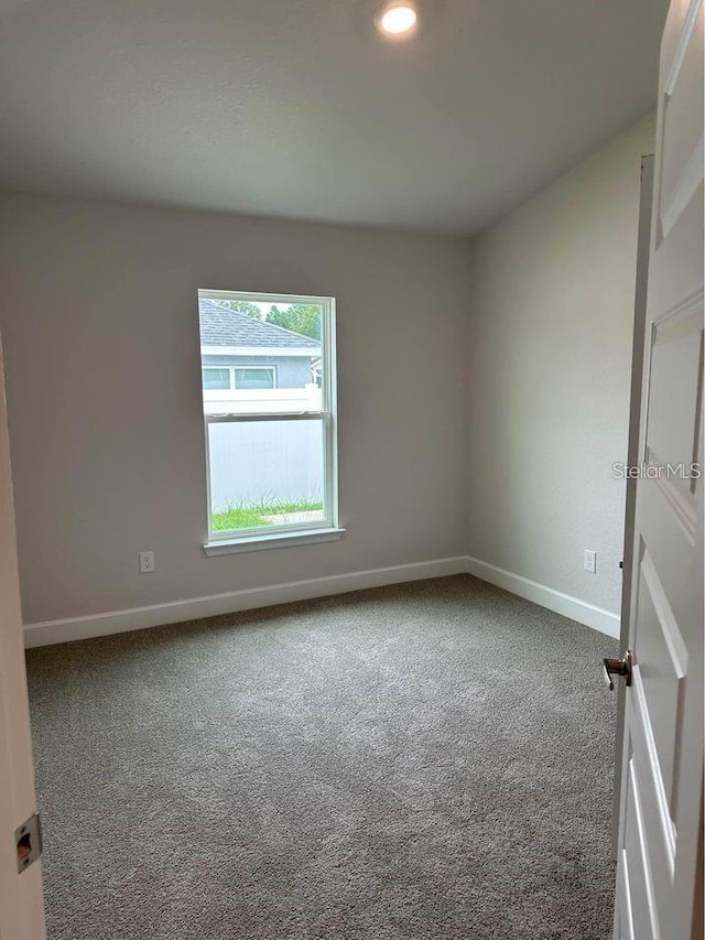 carpeted spare room with baseboards