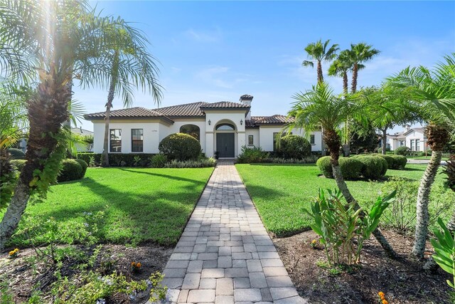 11706 Waterstone Loop Dr, Windermere, FL 34786 - mediterranean / spanish home featuring a tile roof, a front yard, stucco siding, and a chimney