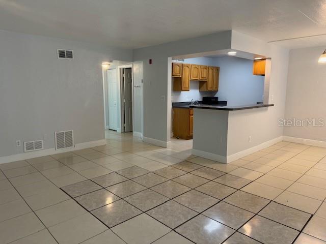 900 S Peninsula Dr Unit 208, Daytona Beach, FL 32118 - kitchen with light tile patterned flooring, dark countertops, and baseboards