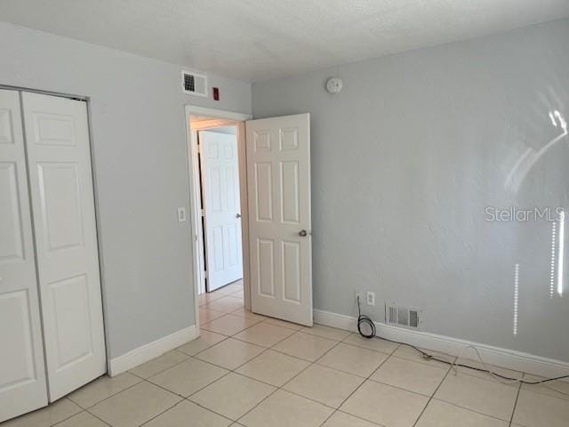 900 S Peninsula Dr Unit 208, Daytona Beach, FL 32118 - unfurnished room featuring light tile patterned floors, baseboards, and a smoke detector