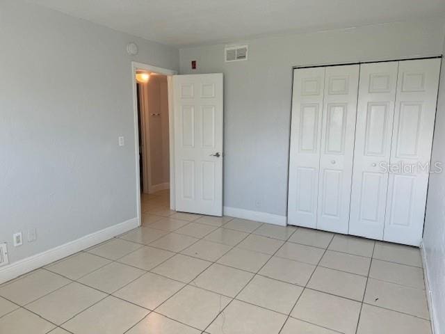 900 S Peninsula Dr Unit 208, Daytona Beach, FL 32118 - unfurnished bedroom with light tile patterned floors, a closet, and baseboards