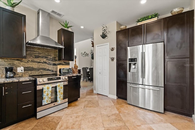 16 Sawfish Ct, Kissimmee, FL 34759 - kitchen with appliances with stainless steel finishes, wall chimney range hood, tasteful backsplash, light stone counters, and dark brown cabinetry