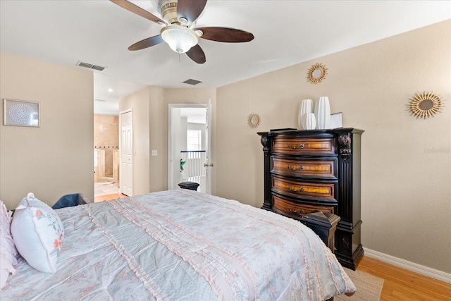 16 Sawfish Ct, Kissimmee, FL 34759 - bedroom with light wood-style floors, baseboards, ensuite bathroom, and a ceiling fan