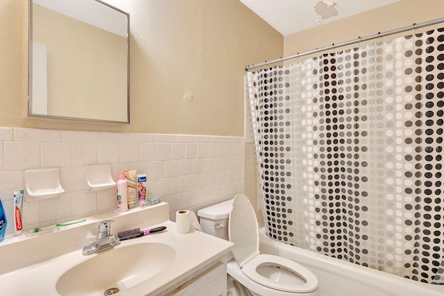 6524/6526 12th St W, Bradenton, FL 34207 - full bath with a textured ceiling, toilet, shower / tub combo with curtain, tile walls, and a wainscoted wall