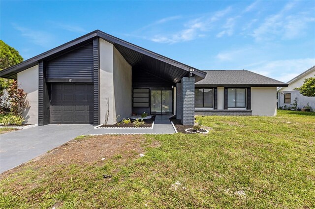 17 S Flag Ct, Kissimmee, FL 34759 - mid-century home featuring a front lawn, concrete driveway, a garage, and stucco siding